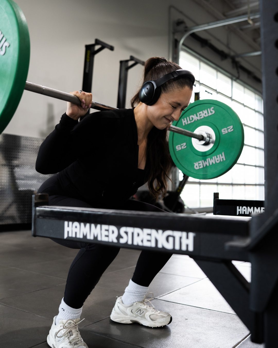 Brooke doing a barbell squat in the gym
